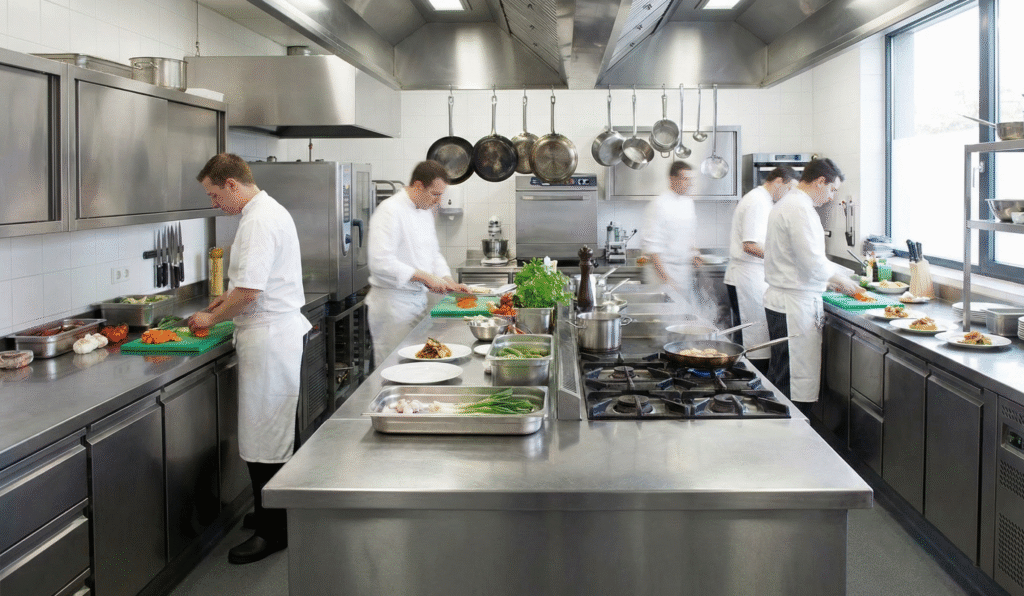Commercial restaurant kitchen with stainless steel equipment needing Class K fire extinguishers for grease fire safety